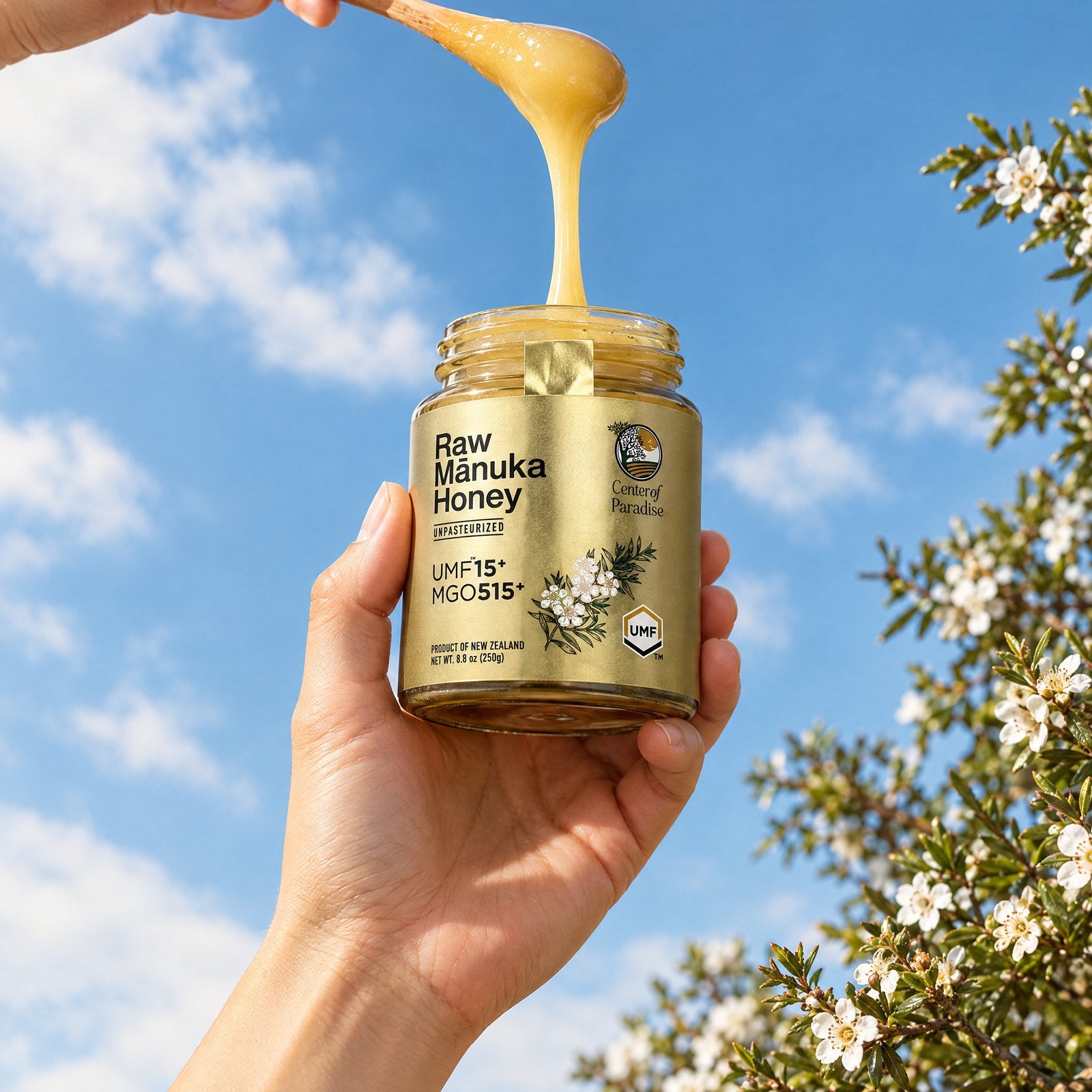 A jar of Center of Paradise raw mānuka honey held up against a blue sky