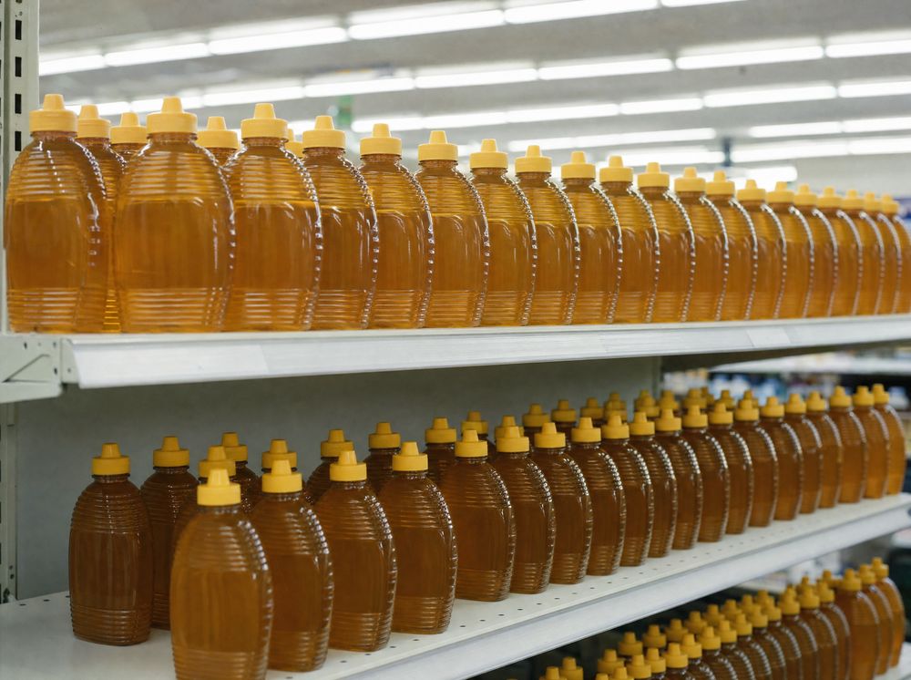 Generic plastic honey bottles on a supermarket shelf